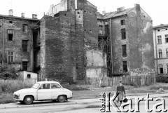 1992, Kraków, Polska.
Krakowski Kazimierz - kobieta przechodzi ulicą, przy której zaparkowano syrenę. W tle zniszczone kamienice.
Fot. Jerzy Szot, zbiory Ośrodka KARTA
