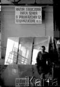 1981, Sandomierz, Polska.
Robotnik w Hucie Szkła w Sandomierzu siedzi obok tafli szkła, nad jego głową napis: „Każda stłuczona tafla szkła o powierzchni 1.2 to wyrzucone 28 zł”.
Fot. Piotr Dylik, zbiory Ośrodka Karta.
