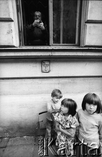 1981, Kraków, Polska.
Dzieci pod oknem, z którego wygląda staruszka.
Fot. Piotr Dylik, zbiory Ośrodka Karta.