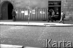 Marzec 1981, Kraków, Polska.
Krakowska ulica - nalepione na płot druki opozycyjne (dotyczące m.in. gotowości strajkowej 20.03.1981) mijają przechodnie.
Fot. Piotr Dylik, zbiory Ośrodka Karta.