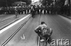 1989, Polska.
Demonstracja Niezależnego Zrzeszenia Studentów pod konsulatem ZSRR. Student zapala świeczki, w głębi kordon milicji.
Fot. Piotr Dylik, zbiory Ośrodka KARTA