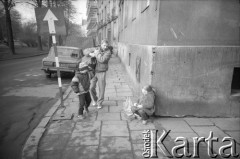 1989, Kraków, Polska.
Scena uliczna - mężczyna z dzieckiem mija dziewczynkę sprzedającą prawdopodobnie owoce. 
Fot. Piotr Dylik, zbiory Ośrodka KARTA