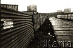 lata 80., Polska.
Blokowisko (akademiki?) i ogrodzenie, na którym nalepiono kartkę z napisem 