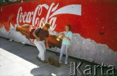 Lata 90., Kraków, Polska.
Płot z reklamą Coca-Coli. Na zdjęciu dziewczynka gra na trąbce.
Fot. Piotr Dylik, zbiory Ośrodka KARTA