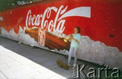 Lata 90., Kraków, Polska.
Płot z reklamą Coca-Coli. Na zdjęciu dziewczynka gra na trąbce.
Fot. Piotr Dylik, zbiory Ośrodka KARTA