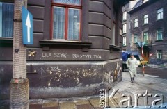 Lata 90., Kraków, Polska.
Napis na murze. Na zdjęciu meżczyzna w płaszczu.
Fot. Piotr Dylik, zbiory Ośrodka KARTA