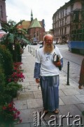 Lata 90., Kraków, Polska.
Na zdjęciu brodaty mężczyzna w jeansowym stroju przypominającym habit idzie przez plac Dominikański. W tle kościół Franciszkanów. 
Fot. Piotr Dylik, zbiory Ośrodka KARTA
