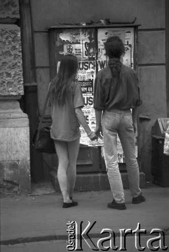 1992, Kraków, Polska.
Para młodych ludzi czyta ogłoszenia na plakatach rozklejonych na ścianie kamienicy.
Fot. Piotr Dylik, zbiory Ośrodka KARTA.