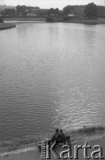 1992, Kraków, Polska.
Widok na Wisłę z Bulwaru Czerwieńskiego na wysokości Wawelu. Na pierwszym planie para siedząca na ławce nad brzegiem rzeki, w oddali most Dębnicki. Na horyzoncie Kopiec Niepodległości im. Józefa Piłsudskiego.
Fot. Piotr Dylik, zbiory Ośrodka KARTA