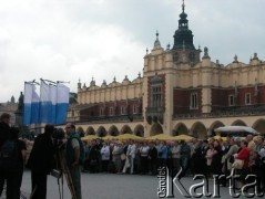 27.08.2004, Kraków, Polska.
Pogrzeb Czesława Miłosza. Sukiennice. Pomnik Adama Mickiewicza. Flagi biało-niebieskie. Ludzie oczekujący na przemarsz konduktu.
Fot. Piotr Dylik, zbiory Ośrodka KARTA