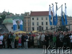 27 sierpnia 2004, Kraków Rynek Główny, Polska.
Pogrzeb Czesława Miłosza. Kościół św. Wojciecha. Flagi biało-niebieskie. Ludzie oczekujący na przemarsz konduktu.
Fot. Piotr Dylik, zbiory Ośrodka KARTA.
 27.08.2004, Kraków, Polska.