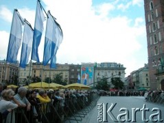 27.08.2004, Kraków, Polska.
Pogrzeb Czesława Miłosza. Kościół Mariacki. Flagi biało-niebieskie. Ludzie oczekujący na przemarsz konduktu.
Fot. Piotr Dylik, zbiory Ośrodka KARTA