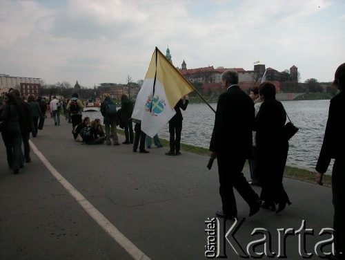 08.04.2005, Kraków, Polska.
Żałoba po śmierci Jana Pawła II. Bulwary. Ludzie maszerujący nad Wisłą. Flag a z kirem. W tle Wawel.
Fot. Piotr Dylik, zbiory Ośrodka KARTA