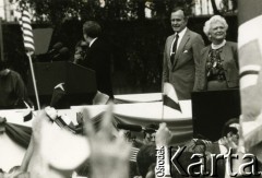11.07.1989, Gdańsk, Polska.
Wizyta prezydenta Stanów Zjednoczonych Ameryki George`a Busha w Polsce w dniach 9-11 lipca 1989 roku. Spotkanie George`a Busha z polską społecznością na placu przed Stocznią Gdańską. Z prawej stoją Barbara i George Bush, przy mównicy Lech Wałęsa, z lewej jego żona - Danuta Wałęsa.
Fot. Jan Juchniewicz, zbiory Ośrodka KARTA