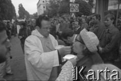 Sierpień 1980, Gdańsk, Polska.
Strajk w Stoczni Gdańskiej im. Lenina. Msza święta na terenie stoczni, ksiądz Henryk Jankowski udziela komunii świętej.
Fot. Witold Górka, zbiory Ośrodka KARTA