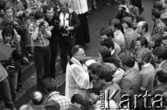 Sierpień 1980, Gdańsk, Polska.
Strajk w Stoczni Gdańskiej im. Lenina. Msza święta na terenie stoczni. Ksiądz udziela komunii świętej, z lewej  fotoreporterzy.
Fot. Witold Górka, zbiory Ośrodka KARTA