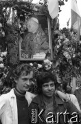 Sierpień 1980, Gdańsk, Polska.
Strajk w Stoczni Gdańskiej im. Lenina. Mężczyźni pod bramą stoczni, na której zawieszono kwiaty i portret Jana Pawła II.
Fot. Witold Górka, zbiory Ośrodka KARTA