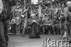 Sierpień 1980, Gdańsk, Polska.
Strajk w Stoczni Gdańskiej im. Lenina. Msza święta na terenie stoczni. Widoczna klęcząca kobieta, stoczniowcy, fotoreporterzy i tłum zgromadzony za bramą.
Fot. Witold Górka, zbiory Ośrodka KARTA