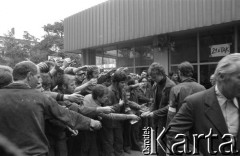 Sierpień 1980, Gdańsk, Polska.
Strajk w Stoczni Gdańskiej im. Lenina. Robotnicy przekazują sobie fotografie.
Fot. Witold Górka, zbiory Ośrodka KARTA