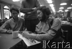 Sierpień 1980, Gdańsk, Polska.
Strajk w Stoczni Gdańskiej im. Lenina. Sala BHP, przerwa w obradach Międzyzakładowego Komitetu Strajkowego.  Mężczyźni przy stole, jeden z nich z kartką z napisem 