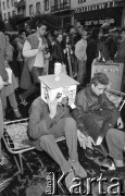 21.10.1988, Wrocław, Polska.
Happening Pomarańczowej Alternatywy na ulicy Świdnickiej – Domek na Świdnickiej. Dwaj uczestnicy siedzą na łóżku polowym. Jeden z nich ma na głowie tekturowy domek.
Fot. Mieczysław Michalak, zbiory Ośrodka KARTA
