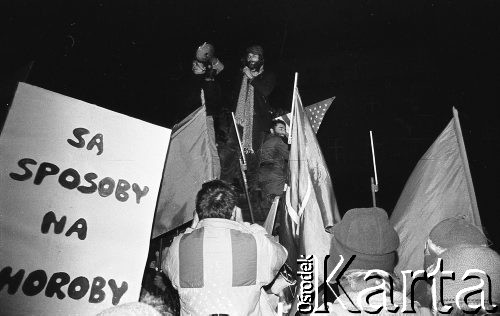 7.11.1988, Wrocław, Polska.
Happening Pomarańczowej Alternatywy – Czerwony Marsz Rewolucji. Wiec pod pomnikiem Hrabiego Aleksandra Fredry na Rynku Starego Miasta. Waldemar Fydrych (Major) i uczestnik przebrany za Fidela Castro stoją na pomniku. Słuchacze z plakatem: są sposoby na choroby.
Fot. Mieczysław Michalak, zbiory Ośrodka KARTA
