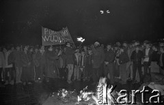 12.12.1988, Wrocław, Polska.
Happening Pomarańczowej Alternatywy na ulicy Świdnickiej - Wigilia Stanu Wojennego. Waldemar Fydrych (Major) wśród tłumu patrzącego na płonące tekturowe czołgi i tarcze ZOMO. Transparent: pomścimy wujka i ciocię.
Fot. Mieczysław Michalak, zbiory Ośrodka KARTA