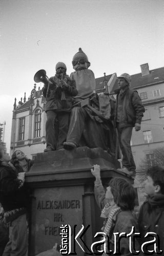 7.02.1989, Wrocław, Polska.
Happening Pomarańczowej Alternatywy – Śledzik na Świdnickiej czyli Zakończenie Karnawału. Waldemar Fydrych (Major) stoi na pomniku Hrabiego Aleksandra Fredry na Rynku Starego Miasta. Na pomnik założono maskę generała Wojciecha Jaruzelskiego.
Fot. Mieczysław Michalak, zbiory Ośrodka KARTA
