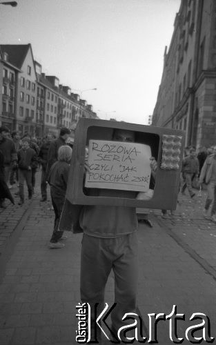 7.02.1989, Wrocław, Polska.
Happening Pomarańczowej Alternatywy na ulicy Świdnickiej – Śledzik na Świdnickiej czyli Zakończenie Karnawału. Chodzący telewizor z informacją: różowa seria czyli jak pokochać ZSRR?
Fot. Mieczysław Michalak, zbiory Ośrodka KARTA
