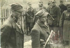 1944-1945, okolice Wilna. 
Żołnierze Armii Krajowej na zbiórce. Z przodu po lewej adiutant 5 Wileńskiej Brygady Armii Krajowej podporucznik Longin Wojciechowski, po prawej dowódca 3 plutonu –  porucznik Antoni Rymsza. 
Fot. NN, Studium Polski Podziemnej w Londynie