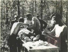 1944-1945, okolice Zamościa 
9 Pułk Piechoty Legionów Armii Krajowej. Doktor Garlicki opatruje rannego. 
Fot. NN, Studium Polski Podziemnej w Londynie