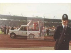 29.05.1982, Londyn, Anglia, Wielka Brytania.
Spotkanie papieża Jana Pawła II z wiernymi na stadionie narodowym Wembley. Na pierwszym planie widoczny policjant, za nim przejeżdża papież w papamobile. 
Fot. NN, Studium Polski Podziemnej w Londynie