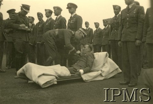 1941-1943, Wielka Brytania.
Polskie Siły Powietrzne w Wielkiej Brytanii. Generał Władysław Sikorski, przypinający odznaczenie rannemu żołnierzowi, leżącemu na noszach.
Fot. NN, Instytut Polski im. Gen. Sikorskiego w Londynie [Kolekcja mjr Piotra Dudzińskiego, dowódcy 304 Dywizjonu Bombowego 