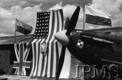 1943, Heston, Anglia, Wielka Brytania.
Wizyta amerykańskich lotników w 303 Dywizjonie Myśliwskim. Spitfire na tle flagi polskiej, angielskiej i amerykańskiej.
Fot. NN, Instytut Polski i Muzeum im. gen. Sikorskiego w Londynie