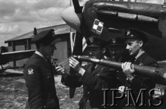 1943, Heston, Anglia, Wielka Brytania.
Wizyta amerykańskich lotników w 303 Dywizjonie Myśliwskim. Polacy: Roman Nartowicz, Stefan Baran i Bronisław Białecki demonstrują uzbrojenie Spitfire'a amerykańskiemu lotnikowi.
Fot. NN, Instytut Polski i Muzeum im. gen. Sikorskiego w Londynie