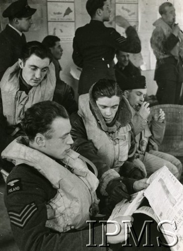 1940-1941, Wielka Brytania.
Lotnicy 306 Dywizjonu Myśliwskiego w gotowości bojowej, z gazetą siedzi sierż. Stanisław Wieprzkowicz (zginął nad Francją we wrześniu 1941), obok sierż. Jan Śmigielski, za nim (z fajką) por. Józef Żulikowski, z lewej sierż. Leon Kosmowski. Strzałkami rzuca ppor. Józef Jeka, w głębi z prawej stoi por. Edward Jankowski.
Fot. NN, Instytut Polski i Muzeum im. gen. Sikorskiego w Londynie [sygn. 4734]