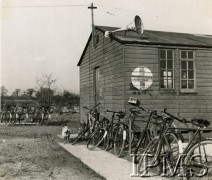 1940-1944, Wielka Brytania.
Rowery przed budynkiem na lotnisku jednego z polskich dywizjonów. Na ścianie oznaczenie Czerwonego Krzyża, na dachu zamontowany głośnik.
Fot. NN, Instytut Polski i Muzeum im. gen. Sikorskiego w Londynie [sygn. 1892-20]