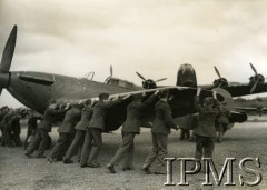 1941-1945, Wielka Brytania.
Junacy (sieroty wojenne), uczniowie szkoły lotniczej podczas zajęć na lotnisku. Chłopcy pomagają w odkołowaniu myśliwca typu Hurricane.
Fot. NN, Instytut Polski i Muzeum im. gen. Sikorskiego w Londynie [sygn. KEY-2257-8]