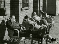 1940-1941, Wielka Brytania.
Piloci 306 Dywizjonu Myśliwskiego odpoczywają przed budynkiem na lotnisku, trzeci od lewej siedzi por. Marian Skalski (zginął 20.10.1941 pilotując zestrzelony nad Anglią i wyremontowany niemiecki samolot Bf 109F).
Fot. NN, Instytut Polski i Muzeum im. gen. Sikorskiego w Londynie [sygn. 4756]