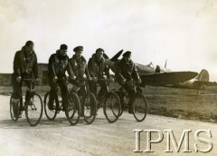 1940-1943, Wielka Brytania.
Piloci 306 Dywizjonu Mysliwskiego jadą na rowerach na terenie bazy lotniczej. Od lewej: NN, NN, Jan Śmigielski, Edward Martens, NN.
Fot. NN, Instytut Polski i Muzeum im. gen. Sikorskiego w Londynie [sygn. 1892-1]