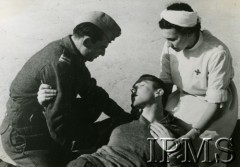 1940-1949, brak miejsca.
Sanitariuszka i żołnierz podtrzymują rannego podczas ćwiczeń.
Fot. NN, Instytut Polski i Muzeum im. gen. Sikorskiego w Londynie  [szuflada 36]