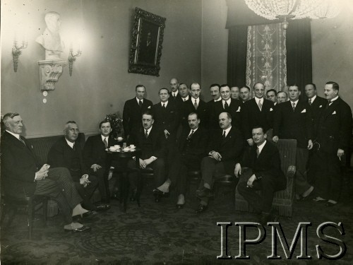 2.12.1934, Warszawa, Polska.
Spotkanie ministra przemysłu i handlu Rumunii Iona Manolescu-Strunga (1. z lewej) z wiceministrem spraw zagranicznych Janem Szambekiem (4. z lewej). Towarzyszą im m.in.: minister przemysłu i handlu Polski Henryk Floyar-Raychman (2. z lewej), wicemarszałek Sejmu Wacław Makowski (siedzi 5. z lewej), poseł nadzwyczajny i minister pełnomocny Rumunii w Polsce Victor Cadere (siedzi 2. z prawej), wiceminister rolnictwa i reform rolnych Roger Raczyński (siedzi 1. z prawej), wicedyrektor Wydziału Wschodniego Departamentu Polityczno-Ekonomicznego MSZ Tadeusz Schatzel (stoi 5. z prawej), szef Gabinetu Ministra Spraw Zagranicznych Roman Dębicki (6. z lewej) oraz szef Protokołu Dyplomatycznego MSZ Karol Romer (stoi 1. z prawej).
 Fot. NN, Instytut Polski im. Gen. Sikorskiego w Londynie [teczka 133 – dyplomaci; fotografie przesłane przez siostrzeńca Jana Szembeka K. Mycielskiego z Johanesburga]