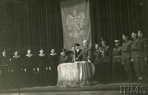 1940-1943, brak miejsca.
Uroczystości z udziałem gen. Władysława Sikorskiego (stoi w środku). Z lewej stoją marynarze. W tle wisi flaga z Białym Orłem.
Fot. NN, Instytut Polski i Muzeum im. gen. Sikorskiego w Londynie