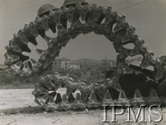 1944, Ankona, Włochy.
Dwa żołnierskie hełmy leżą na gąsienicy zniszczonego czołgu, w tle fragment miasta.
Fot. NN, Instytut Polski i Muzeum im. gen. Sikorskiego w Londynie

