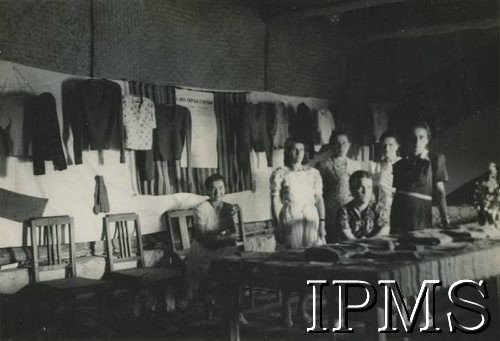 1943-1947, Valivade, Indie.
Kobiety z kursu trykotarskiego przy wystawie swoich prac. [Osiedle stałe w Valivade zostało wybudowane wiosną 1943 roku dla polskich uchodźców (głównie dla kobiet z dziećmi), którzy trafili do Iranu wraz z nowoutworzonym Wojskiem Polskim pod dowództwem generała Władysława Andersa. Posiadało m.in. polską administrację samorządową, kościół, szkoły, teatr, sklepy, cukiernie, szpitale, straż pożarną. W latach 1943–1947 przez osiedle przeszło około pięciu tysięcy Polaków].
Fot. NN, Instytut Polski i Muzeum im. gen. Sikorskiego w Londynie [album 147 - polskie osiedla w Indiach].