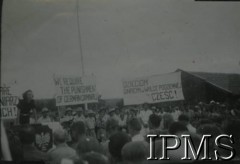 1943-1947, prawdopodobnie Valivade, Indie.
Uroczystość w osiedlu dla polskich uchodźców. Z trybuny przemawia kobieta, widoczne transparenty o treści: Żądamy kary dla niemieckich zbrodniarzy i 