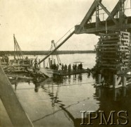 1919-1920, brak miejsca.
Fragment zniszczonego mostu kolejowego, na tratwie stoją cywile i grupa polskich żołnierzy.
Fot. NN, Instytut Polski i Muzeum im. gen. Sikorskiego w Londynie

