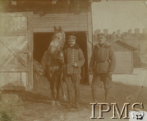 1919-1920, Hrubieszów. Polska.
Oficerowie i koń 3 Dywizjonu Artylerii Konnej im. płk. Włodzimierza Potockiego przed stajnią. Od prawej:  porucznik Włodzimierz Gronowski, major Stefan Trzebiński z koniem Morzukiem. 
Fot. NN, Instytut Polski i Muzeum im. gen. Sikorskiego [album 415c - Dywizjon Artylerii Konnej]