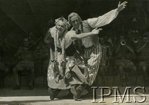 1942, Teheran, Iran.
Występ w obozie dla polskich uchodźców, na scenie para tancerzy w strojach ludowych, w tle orkiestra.
Fot. NN, Instytut Polski i Muzeum im. gen. Sikorskiego w Londynie [album Ludwika Naimskiego].