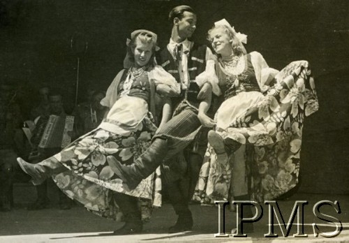 1942, Teheran, Iran.
Występ w obozie dla polskich uchodźców, na scenie tancerze w strojach ludowych, w tle orkiestra.
Fot. NN, Instytut Polski i Muzeum im. gen. Sikorskiego w Londynie [album Ludwika Naimskiego].